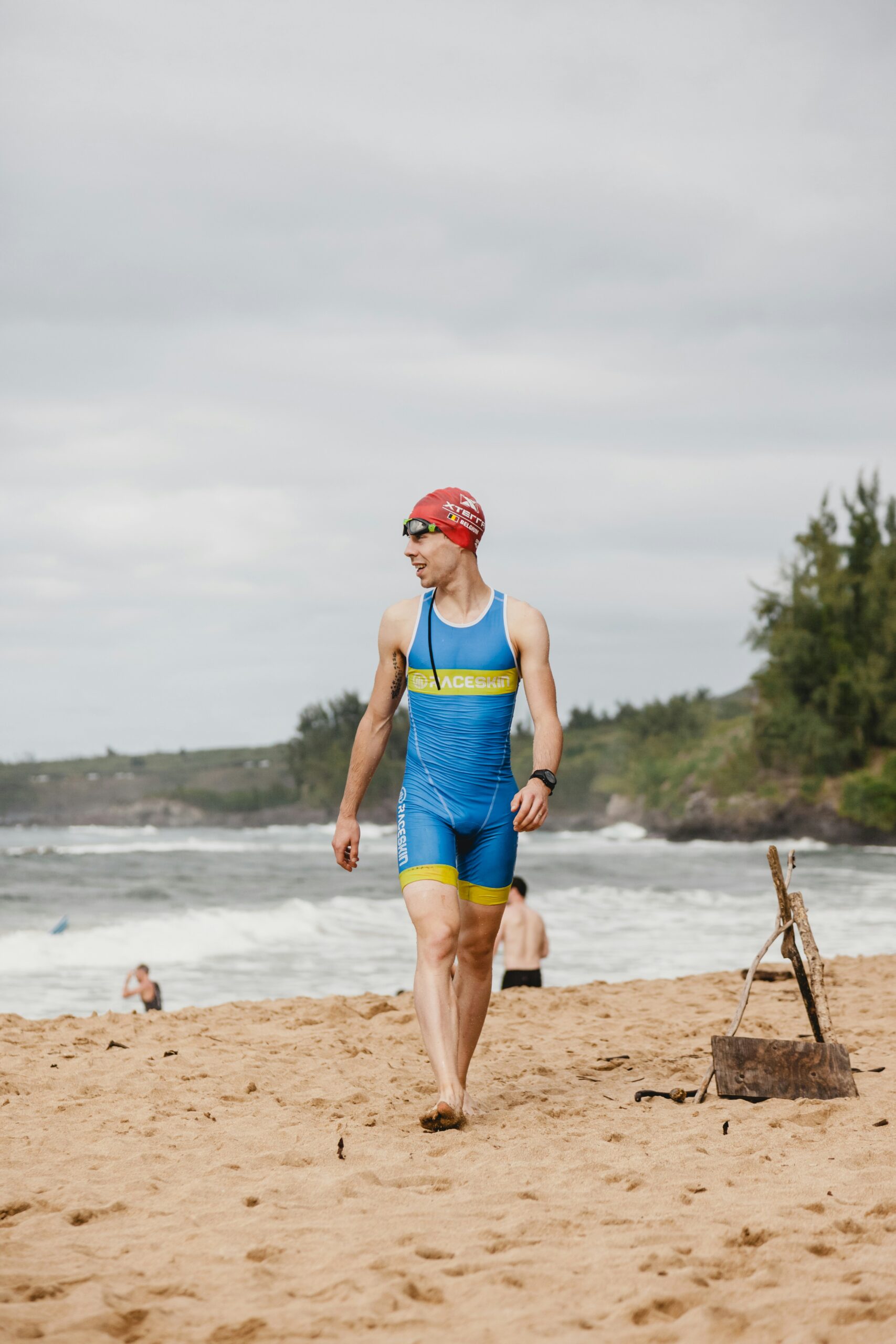 person-paa-strand-med-triathlon-dragt